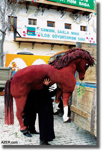 Organizing to set up one of the Novruz exhibitions in downtown Baku. The banner reads: "Samani (sprouted wheat) save me, I'll plant you every year."  Mehdi Mammadov